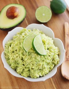 a white bowl filled with rice next to sliced avocado