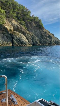 there is a boat in the water near some cliffs