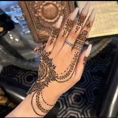 a woman's hand with henna tattoos on it