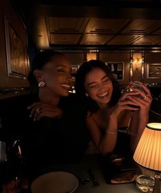 two women sitting at a table drinking wine