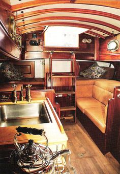 the interior of a boat with wood paneling and leather furniture, including a sink