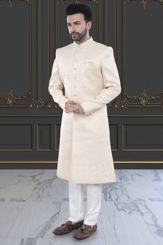 This men's sherwani (traditional Indian attire) features expertly crafted thread and sequin work. The intricate detailing adds a touch of elegance to any occasion. Made from high-quality materials, it offers both style and comfort. Perfect for those seeking a traditional yet sophisticated look. Elegant Off White Sherwani With Resham Embroidery, Elegant Cream Sherwani With Intricate Embroidery, Off White Zari Work Sets For Formal Occasions, Designer Cream Sherwani With Long Sleeves, Elegant Cream Sherwani With Zari Work, Off White Formal Sets With Zari Work, Designer Cream Fitted Kurta, Formal Off-white Sets With Zari Work, Designer Long Sleeve Cream Sherwani