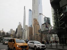 there are many cars that are driving down the street in front of some tall buildings