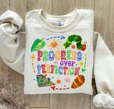 a child's sweatshirt with the words progress over practice on it and colorful images