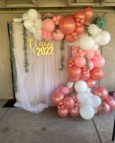 the balloon arch is decorated with pink and white balloons