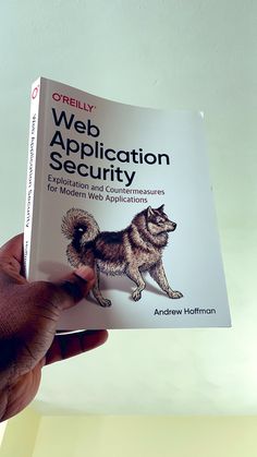 a person holding up a book with a dog on it's front cover that says web application security