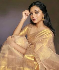 a woman in a gold sari posing for a photo