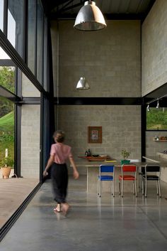 a woman walking through a room with lots of windows