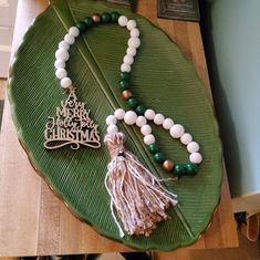 a green plate with a tassel and some beads on it