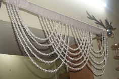 the beaded curtain is hanging from the ceiling in front of a mirror with lights on it