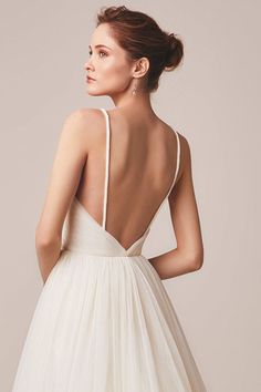 a woman in a white dress with her back to the camera