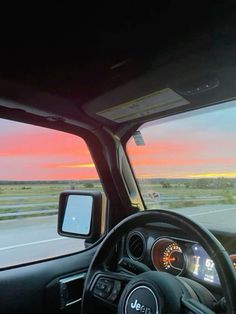 the driver's view from his vehicle as the sun sets