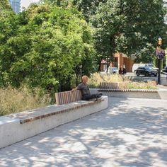 a man sitting on top of a cement bench