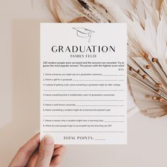 a person holding up a paper with the words graduation on it