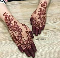 two hands with henna tattoos on them