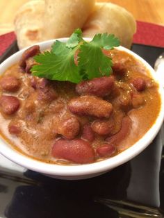 a white bowl filled with beans and garnished with cilantro