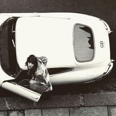 a woman sitting in the back of a white car