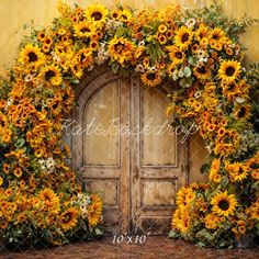 sunflowers and greenery are arranged around an old door