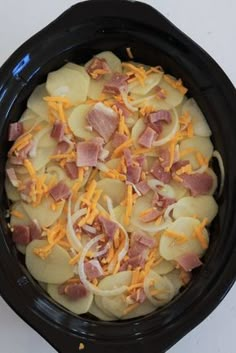 a crock pot filled with potatoes, ham and cheese