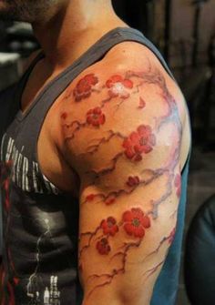 a man's arm with red flowers on it