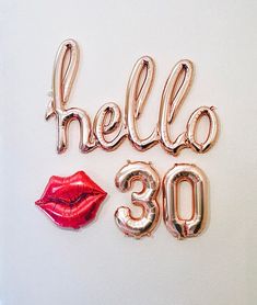 balloons spelling out the word hello 30 with a red lipstick and gold foil balloon letters