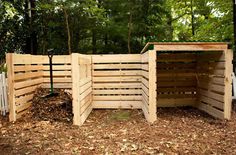 a fence made out of wooden pallets in the middle of a yard with leaves on the ground