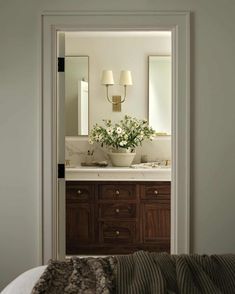 an open door leading to a bathroom with two sinks and a mirror on the wall