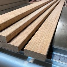 several pieces of wood sitting on top of a metal table next to a measuring ruler