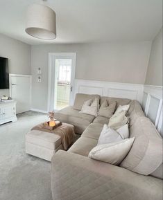 a living room filled with furniture and a flat screen tv on top of a wall