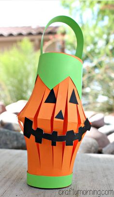 a paper pumpkin bucket sitting on top of a wooden table