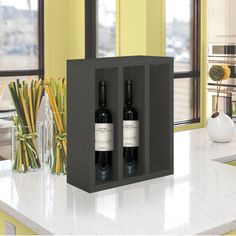 two bottles of wine in a black box on a kitchen counter