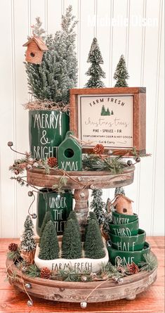 three tiered tray with christmas trees and other items on it, including mugs