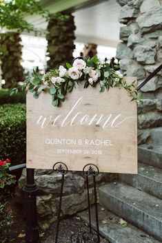 a wooden sign with flowers on it that says welcome to the couple and their wedding date