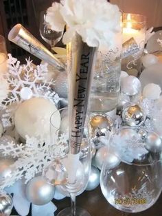 a table topped with silver and white christmas decorations