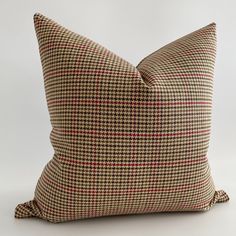 a brown and red checkered pillow on a white background