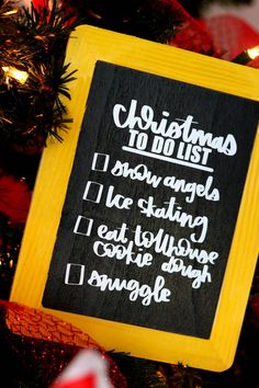 a christmas ornament hanging on a tree with words written in white and black