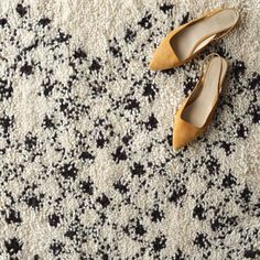 two pairs of shoes sitting on top of a white and black carpet covered in small stars