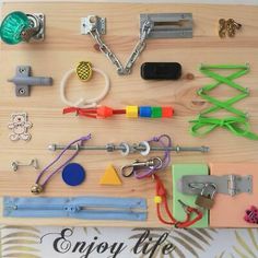 an assortment of items are displayed on a wooden board with the words enjoy life written below it