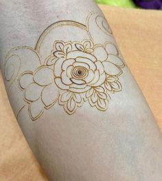 a close up of a person's arm with a flower tattoo design on it