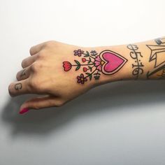 a woman's arm with tattoos on it and flowers around the wrist, which reads happy birthday