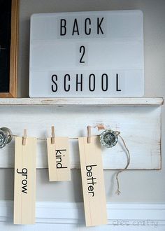 clothes pegs are hanging on the wall next to a sign that says back 2 school