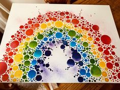 a rainbow made out of watercolors on paper with dots in the shape of a circle