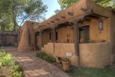 an adobe - style house with potted plants on the outside