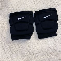 pair of black knee pads with white nike logo