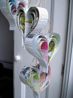 some paper hearts hanging from a door with twine on the front and back ends