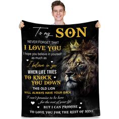 a man holding up a black and gold lion blanket with the words to my son on it