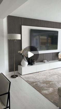 a modern living room with black and white striped wallpaper, large television on the entertainment center