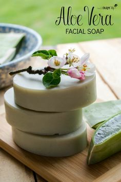 aloe vera facial soap on a cutting board with flowers and leaves in the background