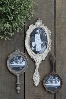 three antique mirrors are hanging on a wooden wall next to a potted plant and two spoons