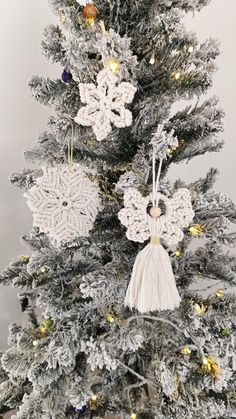 a crocheted christmas tree with snowflakes and ornaments hanging from the branches